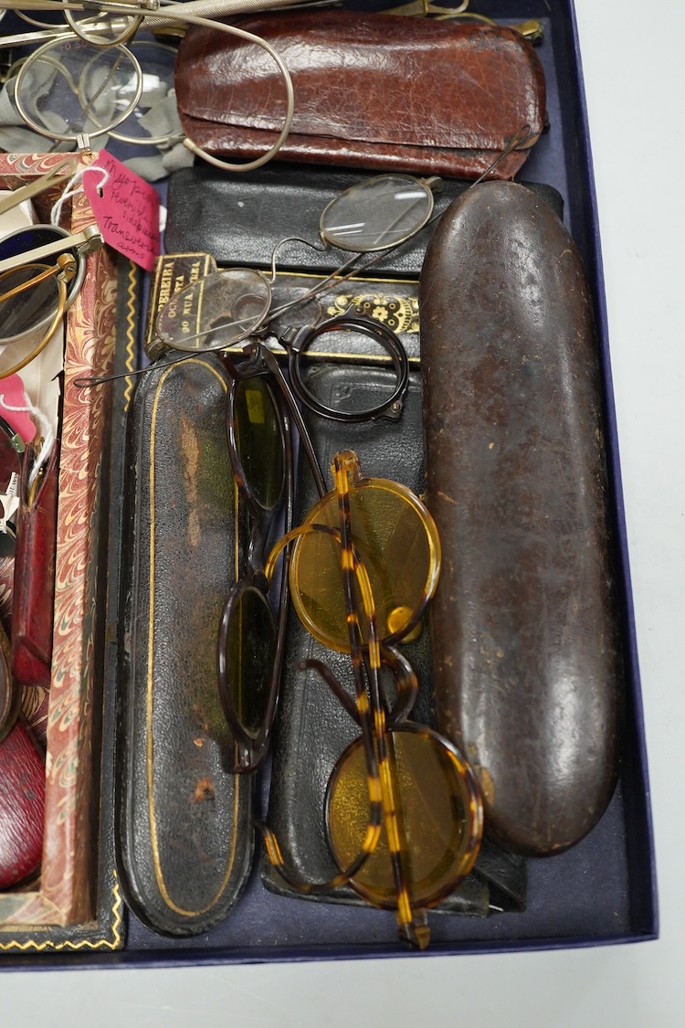 A collection of 18th-20th century steel, nickel, tortoiseshell, brass or faux tortoiseshell spectacles, some cased, five 19th century pince nez, some cased and a quizzing glass etc.